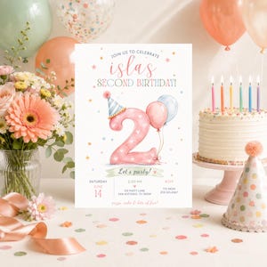 Puede incluir: Una tarjeta de invitación de cumpleaños con un gran número dos rosa con un gorro de fiesta, globos y confeti. El texto dice: JOIN US TO CELEBRATE ISLAS SECOND BIRTHDAY, Let's party!, SATURDAY JUNE 14, 2:00 PM, 123 PARTY LANE SAN ANTONIO, TX 78209, RSVP TO MOM 210.123.4567, pizza, cake & lots of fun!