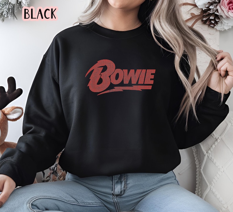 May include: Black sweatshirt with a red "BOWIE" graphic on the front.