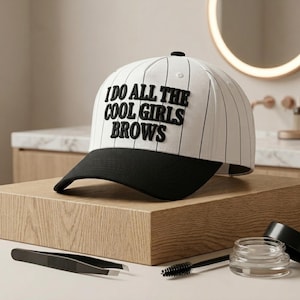 May include: A white baseball cap with thin black pinstripes and a solid black brim. The front of the cap features the embroidered black text I DO ALL THE COOL GIRLS BROWS in a bold, sans-serif font. The cap has a structured crown and a button top.