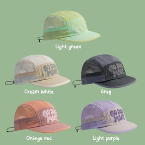 May include: Five five-panel caps with mesh side panels and adjustable back cords. Each cap features the text "GO ONE MORE" on the front panel. The colors include light green, cream white, grey, orange red, and light purple, all with matching brims.