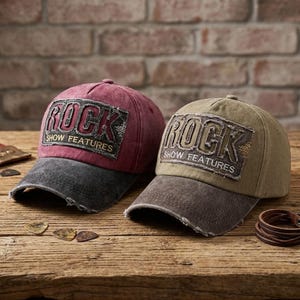 May include: Two baseball caps with distressed finishes. One is maroon with a dark gray brim, the other is olive green with a dark brown brim. Both feature a rectangular patch on the front with the text ROCK SHOW FEATURES in white lettering.