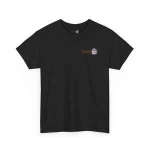 May include: A black short-sleeved t-shirt featuring a small circular logo on the left chest. The logo includes the text Eisenbahn Technik Zentrum and a graphic of a train wheel. The shirt has a standard crew neckline and a plain black back.