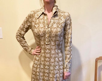 May include: A long-sleeved dress with a collared neckline and a floral print in shades of brown and white.
