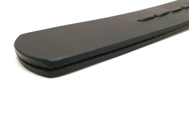 Handcrafted genuine leather paddle featuring black leather construction, polished wooden handle, and braided leather detailing. Premium artisan leatherwork accessory, custom handmade leather product, traditional leather craftsmanship, rustic leather gift, unique handcrafted item, leather collector accessory, durable genuine leather design, artisan crafted leather tool, high quality handmade leather creation.