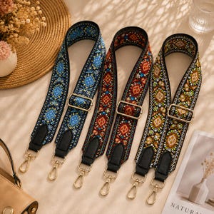 May include: Three adjustable bag straps featuring intricate woven patterns in blue, red, and green colorways. Each strap includes black leather-like end tabs, gold-toned metal hardware, and swivel lobster clasps for secure attachment to various bags.