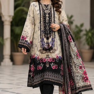 May include: A long-sleeved beige tunic featuring a black and purple floral print, a dark central panel with intricate patterns, and a matching patterned shawl. The outfit is paired with solid black trousers and open-toed black sandals.