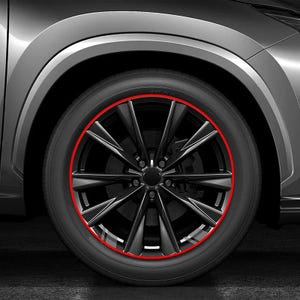 Puede incluir: Una rueda de coche negra con un dise&ntilde;o de radios m&uacute;ltiples y una fina franja decorativa o protector de llanta circular de color rojo vibrante aplicado a lo largo del borde exterior de la rueda, sobre una carrocer&iacute;a gris y un neum&aacute;tico negro.