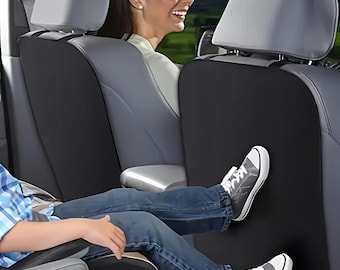 May include: A black car seat back protector made of a smooth, solid material. The rectangular cover is attached to the rear of the front vehicle seat, providing a protective barrier against dirt and scuffs from footwear while maintaining a clean look.