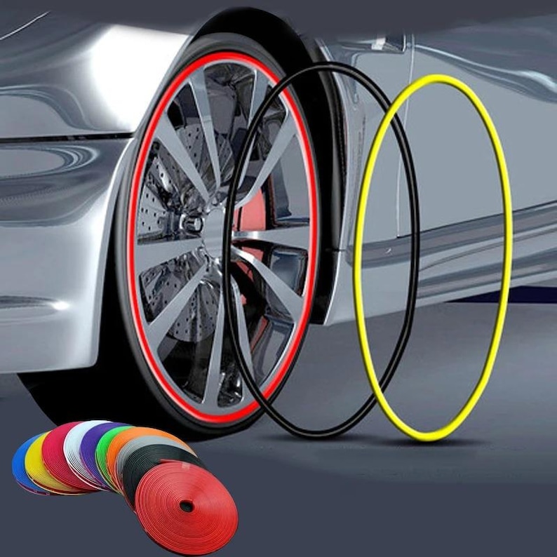 Puede incluir: Un conjunto de tiras adhesivas circulares para protecci&oacute;n de llantas en varios colores, incluyendo rojo, amarillo, negro, azul y naranja. Las tiras se muestran en rollos y aplicadas como un borde decorativo alrededor de una llanta plateada.