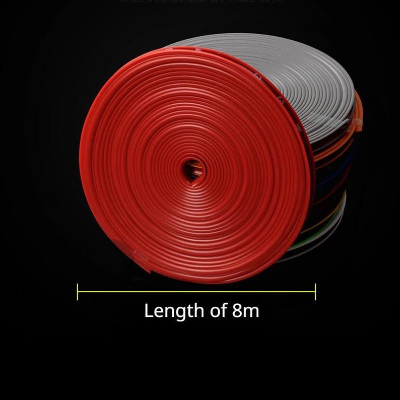 Puede incluir: Un rollo de moldura flexible roja con un perfil en forma de T, apilado junto a otros rollos de varios colores. El texto "Length of 8m" est&aacute; impreso debajo de la bobina, indicando la longitud total de la tira de moldura en este rollo.