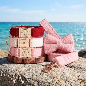 May include: Three pet collars in red, white, and light pink with gold-tone metal buckles engraved with the names Daisy, Coco, and Popo plus phone numbers. A matching light pink leash with a bow attachment and a gold-tone metal swivel snap hook.