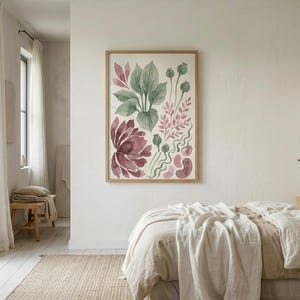 May include: A framed vertical wall art print featuring a watercolour illustration of botanical elements including large green leaves, a deep burgundy flower, and smaller pink and green sprigs, displayed on a plain white wall above a bed.