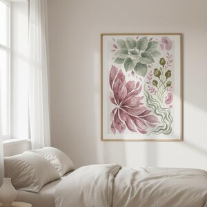 K&ouml;nnte beinhalten: Ein gerahmter Kunstdruck mit einer Aquarellillustration aus gro&szlig;en malvenfarbenen Bl&uuml;tenbl&auml;ttern, gr&uuml;nem Blattwerk und kleinen Samenkapseln. Das Kunstwerk befindet sich in einem hellen Holzrahmen und h&auml;ngt an einer Wand &uuml;ber einem Bett.