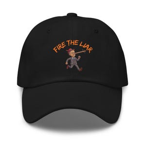 May include: A black baseball cap featuring an embroidered graphic of a person in a grey suit and red hat with an elongated wooden nose. Above the figure, the text FIRE THE LIAR is stitched in orange. The cap has a curved brim and a structured crown.