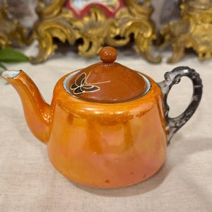 Vintage orange tekanna i lustgods, handtag i spräcklig gren, lock i abstrakt målning