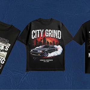 May include: Three black short-sleeve t-shirts. The left shirt features text reading URBAN LEGEND CASH RULES EVERYTHING and a 100 dollar bill graphic. The center shirt shows a car with the text CITY GRIND. The right shirt displays a skull with red eyes.