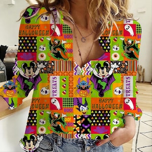 Puede incluir: Una camisa de manga larga con cuello en V y un patrón colorido con temática de Halloween. El estampado incluye personajes de dibujos animados como Mickey Mouse, Stitch y Donald Duck disfrazados, junto con calaveras, fantasmas, calabazas y los textos Happy Halloween, Boo y Treats.