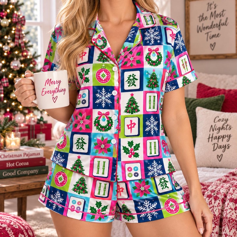 May include: A short-sleeve button-down pajama shirt and matching shorts set featuring a colorful grid pattern of Christmas trees, snowflakes, poinsettias, wreaths, and mahjong tiles. The shirt has a white mug with the text Merry Everything.