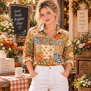 May include: A long-sleeved button-down shirt featuring a patchwork design of various floral patterns in shades of orange, green, and blue. The shirt has a classic collar and white buttons down the front, paired with plain white trousers.