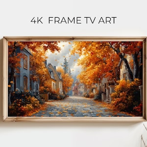 Könnte beinhalten: Ein rechteckiger gerahmter Digitaldruck mit der Aufschrift 4K FRAME TV ART, der eine gepflasterte Straße im Herbst mit leuchtend orangefarbenen und gelben Bäumen, Häusern auf beiden Seiten und Laub auf dem Boden zeigt.