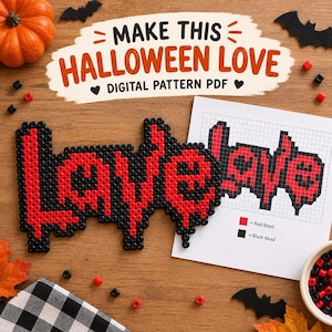 May include: A craft project featuring the word LOVE spelled out in red and black plastic beads, accompanied by a printed grid pattern on white paper. The paper displays the text MAKE THIS HALLOWEEN LOVE DIGITAL PATTERN PDF and a color key.