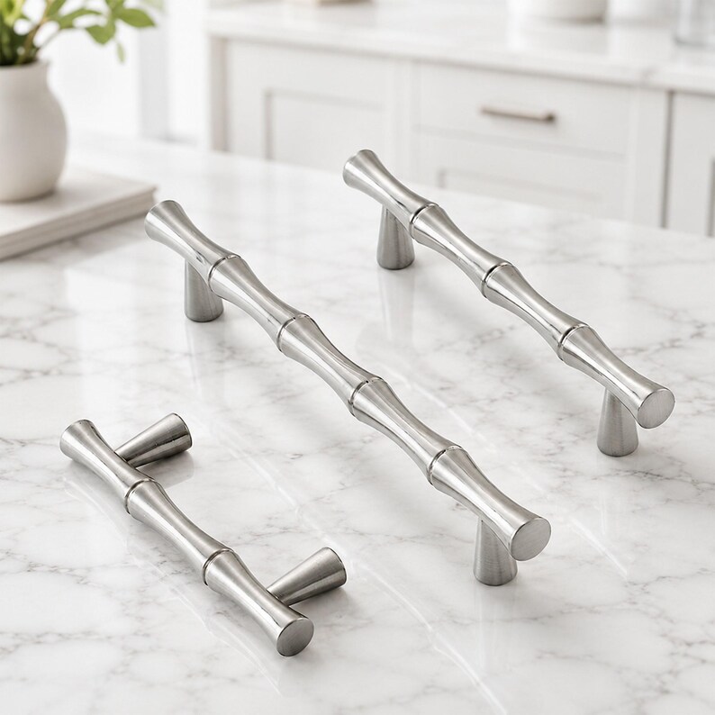 May include: Three silver-toned metal cabinet pulls with a segmented bamboo-inspired design. Each handle features a smooth, polished finish and two conical mounting posts that elevate the bar from the surface, creating a uniform look.