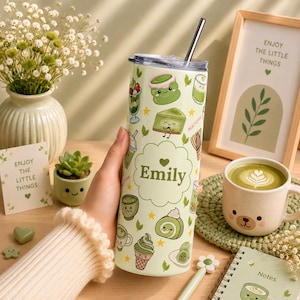 Puede incluir: Un vaso cilíndrico de color verde claro con tapa y pajita de metal, que presenta un patrón repetitivo de ilustraciones de dibujos animados con temática de matcha y el nombre Emily impreso en el centro dentro de una nube festoneada.