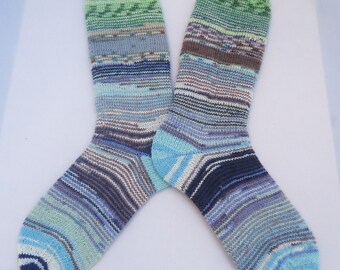 May include: A pair of hand-knitted socks in a colorful striped pattern with shades of blue, green, and white.