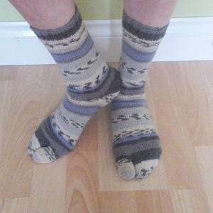 May include: A pair of grey and blue patterned socks with a split toe design.