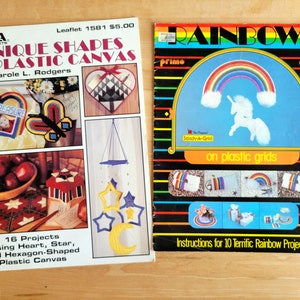 May include: Two vintage craft leaflets. One titled "Unique Shapes in Plastic Canvas" by Carole L. Rodgers, featuring various projects. The other, "Rainbows on plastic grids", with a rainbow and unicorn illustration. Both are for crafting projects.