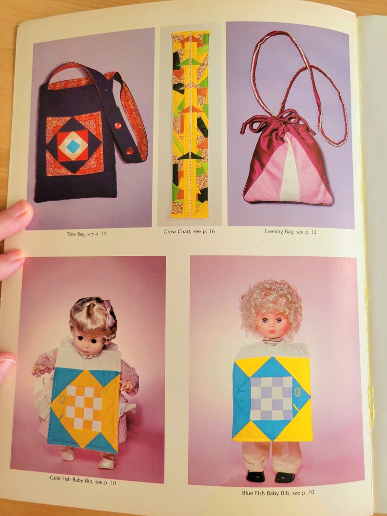 May include: A page from a vintage sewing pattern book featuring a navy tote bag with a geometric design, a colorful grow chart, and a pink evening bag. Also shown are two baby bibs with fish designs.