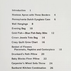 May include: A printed page with the title "Contents" at the top. The page lists various craft projects, including an apron, eyeglass case, wall hangings, an evening bag, baby bibs, a tote bag, and a grow chart.