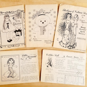 May include: A collection of eight vintage doll and puppet sewing patterns. The patterns feature a snowman puppet, a mermaid doll, a cobbler doll, and two dolls named Thelma and Velma. The patterns are printed on white paper with black ink and include instructions and diagrams.
