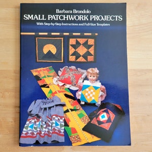 May include: A book titled "SMALL PATCHWORK PROJECTS" by Barbara Brondolo, with step-by-step instructions and full-size templates. The cover features patchwork designs, including a doll wearing a patchwork outfit and other small patchwork projects.