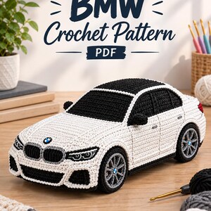Op de afbeelding: Een gehaakt BMW-automodel in wit en zwart met gedetailleerde koplampen, een zwart dak en wielen met het BMW-logo. De tekst BMW Crochet Pattern PDF staat boven de auto, die is gemaakt met garen en haaknaalden.