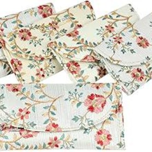 May include: A collection of six floral print wallets. The wallets feature a white background with a repeating pattern of pink flowers and green leaves. Each wallet has a curved flap closure. The wallets are arranged in a fan shape.