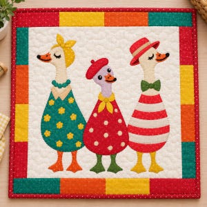 Könnte beinhalten: Ein quadratischer Stoffquilt mit drei Gänse-Applikationen auf cremefarbenem Hintergrund. Die linke Gans trägt ein gelbes Kopftuch und ein blaugrünes Blumenkleid. Die mittlere Gans trägt ein rotes Barett und ein rot gepunktetes Kleid. Die rechte Gans trägt einen roten Hut und ein rot gestreiftes Kleid. Der Rand besteht aus einem bunten Patchwork aus roten, orangen, gelben und blaugrünen Quadraten.