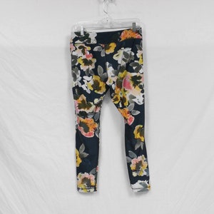 May include: Black leggings with a floral print featuring yellow, pink, and white flowers.