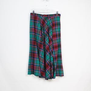 Puede incluir: Una falda de cuadros verdes, rojos y blancos con cintura alta y silueta acampanada.