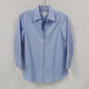 May include: A light blue long-sleeved button-down shirt with a white label that says "Prompt" on it.