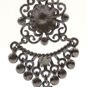 May include: Black filigree dangle earrings with a round black stone in the center and a black bead at the bottom.