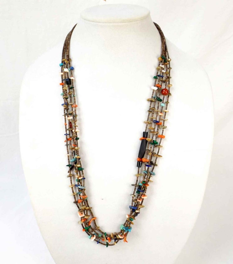 May include: Multi-strand necklace made of brown, turquoise, coral, and other colorful stones. The necklace has a black and green stone clasp.