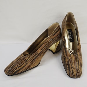 May include: A pair of brown and gold heeled shoes with a woodgrain pattern. The shoes are by the brand "J. Renee".