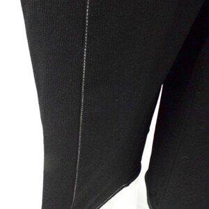 May include: Black long-sleeved shirt with a seam down the side.