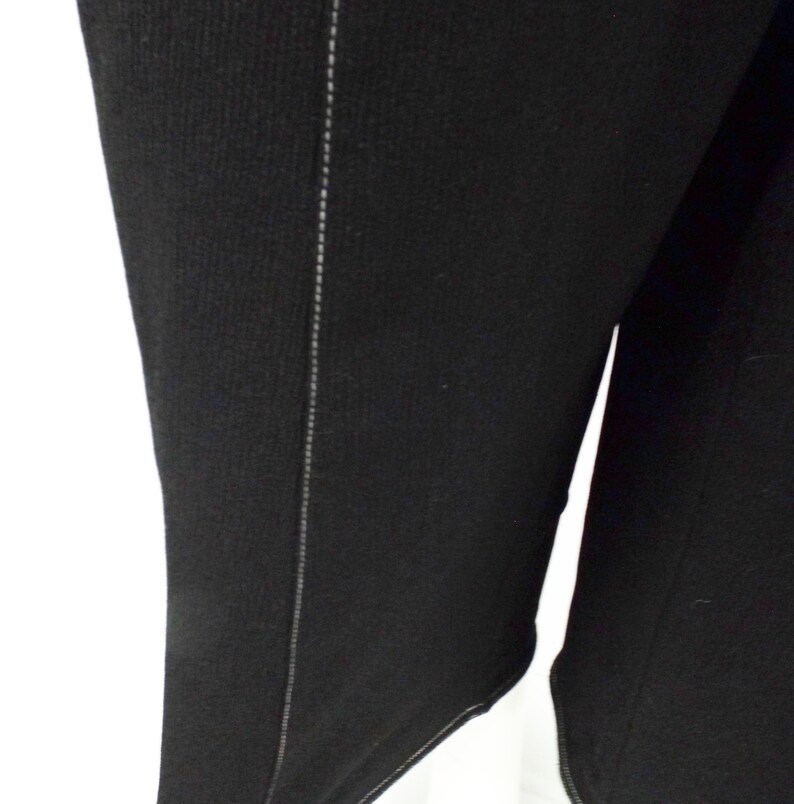 May include: Black long-sleeved shirt with a seam down the side.