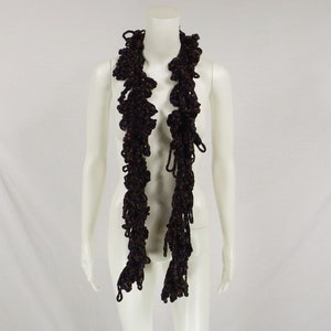 May include: A brown and black crocheted scarf with a ruffled texture.