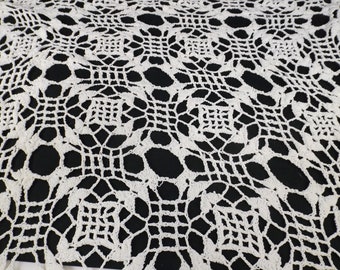 May include: White crocheted tablecloth with a delicate floral pattern. The tablecloth is made of fine yarn and has a delicate, lacy texture.
