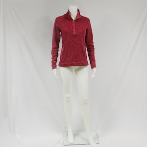 May include: A long-sleeved, red sweater with a mock neck and a button placket. The sweater has a textured, marled appearance.