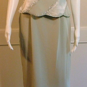May include: A light green formal dress with a beaded bodice and a skirt. The bodice has a diagonal pattern of sequins.