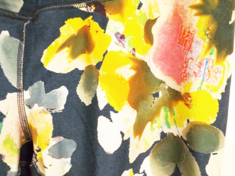 May include: Black leggings with a floral print featuring yellow, pink, and green watercolor-style flowers.